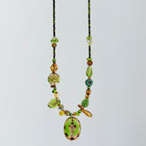 Necklace with green and brown beads on a light gray background